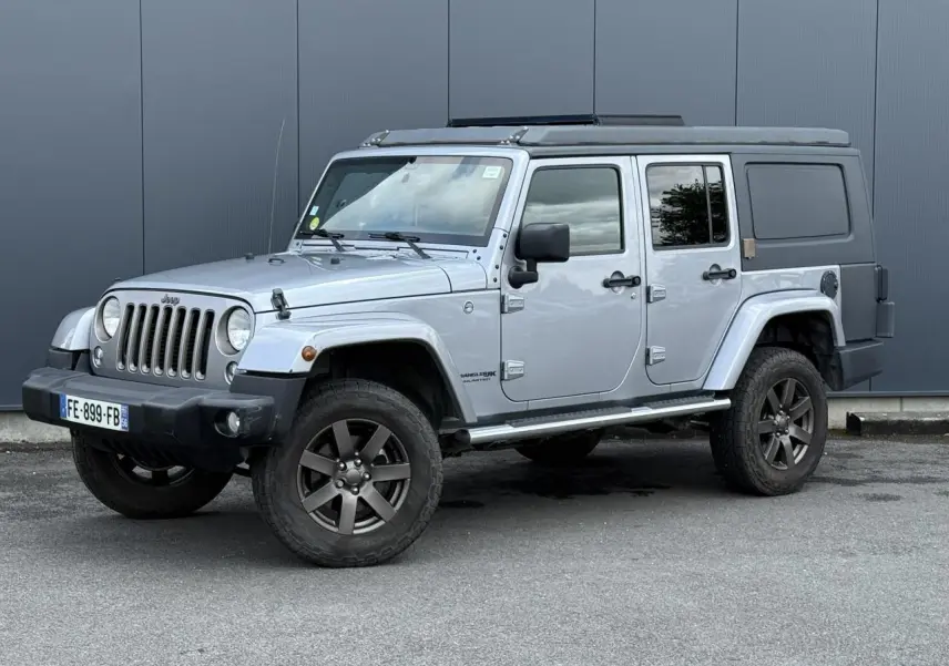 Jeep Wrangler 2.8 CRD 2019 en Billet Silver, vue 3/4 avant gauche avec toit relevable et cellule de vie noire.