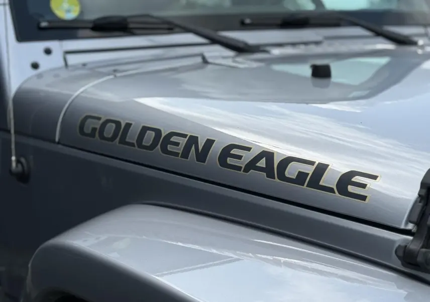 Gros plan sur le capot côté gauche d'un Jeep Wrangler Golden Eagle 2019 couleur Billet Silver avec lettrage doré.