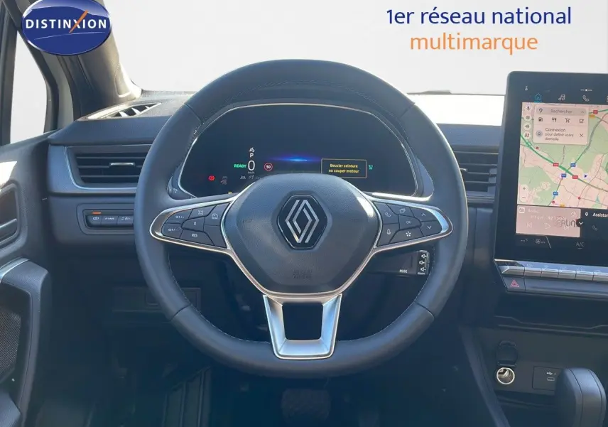 Vue intérieure centrée sur le volant Renault Captur E-Tech Hybrid 2025 avec tableau de bord numérique et écran tactile.