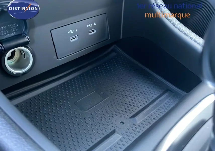 Gros plan sur la console centrale du Renault Captur 2025 avec prise USB double et tapis de rangement noir.