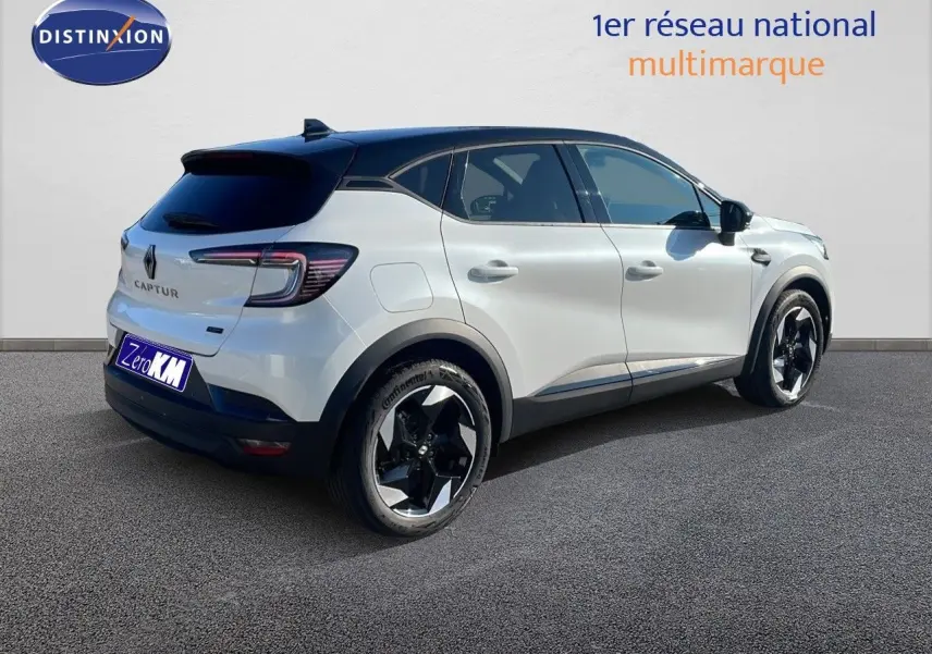 Renault Captur E-Tech hybride blanc nacré avec toit noir, vue 3/4 arrière côté droit, jantes noires distinctives.
