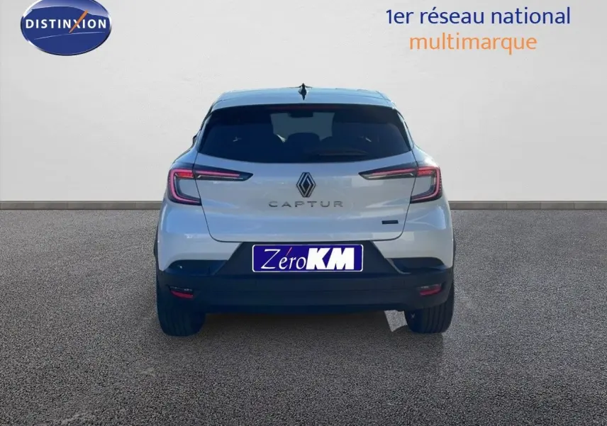 Vue arrière d'un Renault Captur blanc nacré avec toit noir, mettant en valeur ses feux LED et son logo central.
