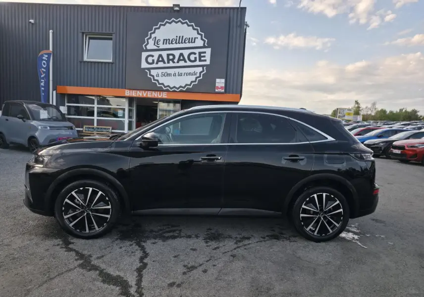DS7 Crossback E-Tense 225 noir en profil droit, avec jantes alliage 19'' et barres de toit aluminium visibles.