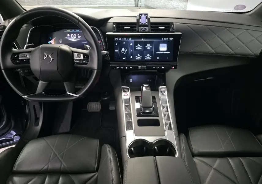 Vue intérieure avant du DS7 Crossback 2024 noir, mettant en valeur le volant cuir, la console centrale moderne et l'écran tactile HD.
