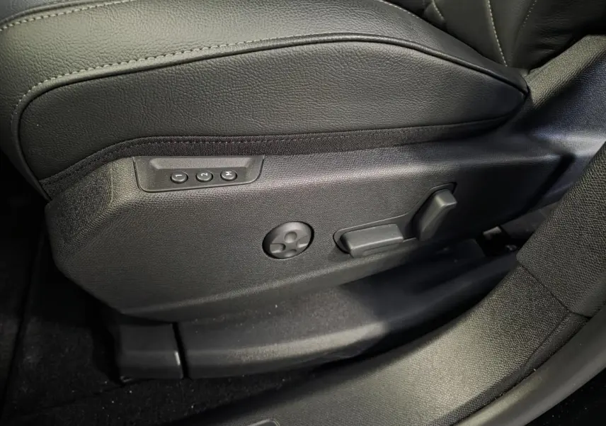 Détail côté gauche du siège avant en cuir noir avec commandes électriques de réglage sur DS7 Crossback 2024.