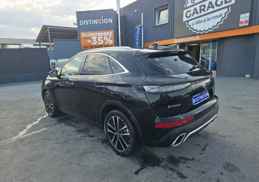 Vue 3/4 arrière droite du DS7 Crossback E-Tense noir métallisé avec jantes 19'' et double sorties d’échappement chromées.