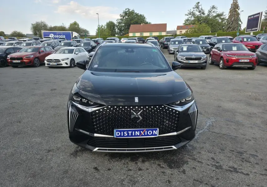 Vue avant d'un DS7 Crossback E-Tense noir avec calandre DS Wings et feux LED distinctifs sur un parking.