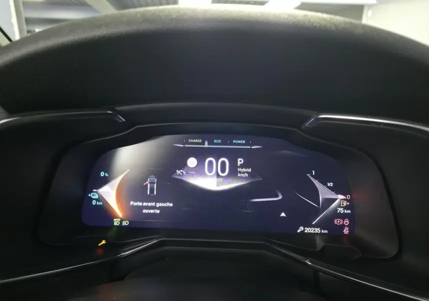 Vue rapprochée du tableau de bord numérique du DS7 Crossback noir, affichant porte avant gauche ouverte et indicateurs hybrides.