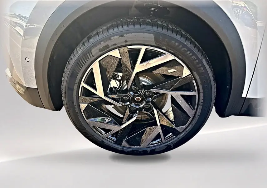 Gros plan sur la roue avant gauche du Renault Symbioz gris rafale, mettant en valeur la jante alu au design géométrique noir et argent.