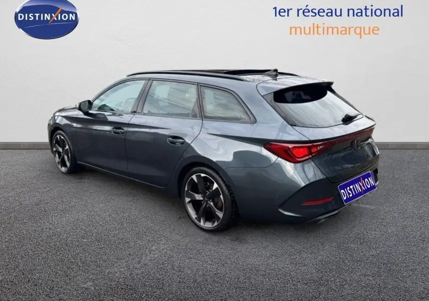 Vue 3/4 arrière droite d'une CUPRA LEON ST 2024 gris magnétique métallisé avec jantes bi-ton et toit ouvrant.