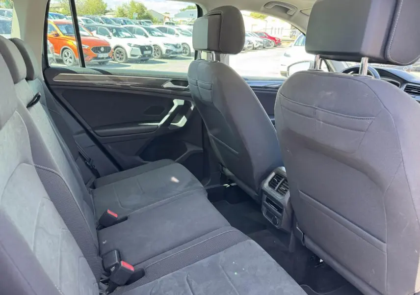 Vue intérieure arrière côté gauche du Volkswagen Tiguan 2.0 TDI 150 DSG 7 Elegance avec sellerie microfleece gris et aérateurs centraux.