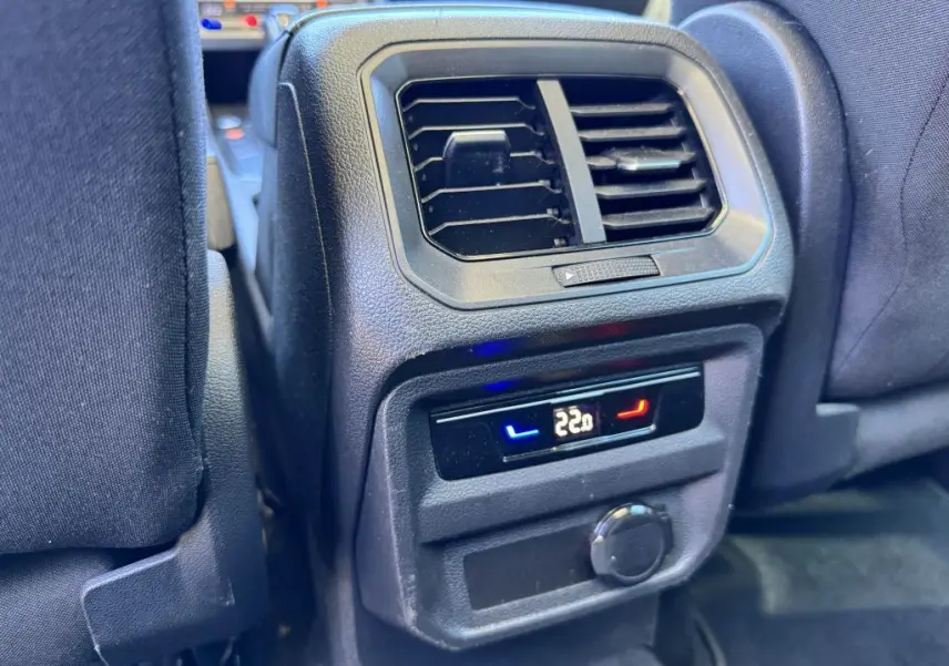 Vue rapprochée de la console arrière avec ventilation et réglage climatisation à 22°C dans un Volkswagen Tiguan gris.