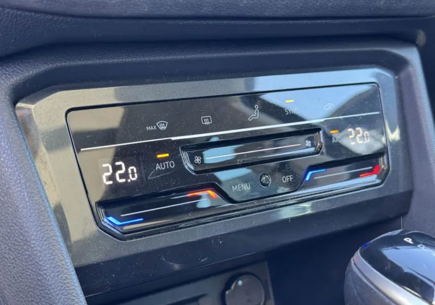Panneau de commande de la climatisation automatique du Volkswagen Tiguan 2.0 TDI gris, affichant 22°C en mode auto.