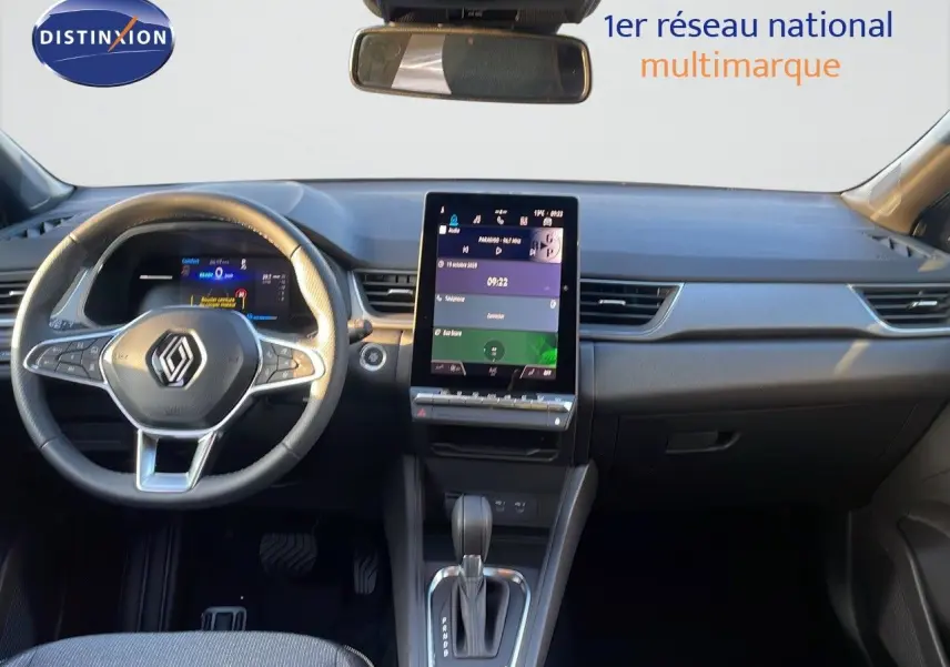 Vue intérieure du tableau de bord du Renault Captur E-Tech gris cassiopée, avec écran tactile central et volant multifonction.