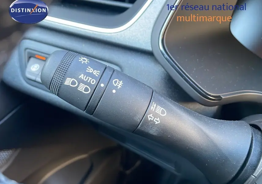 Gros plan sur la commande des feux et clignotants dans l'habitacle du Renault Captur E-Tech gris cassiopée.