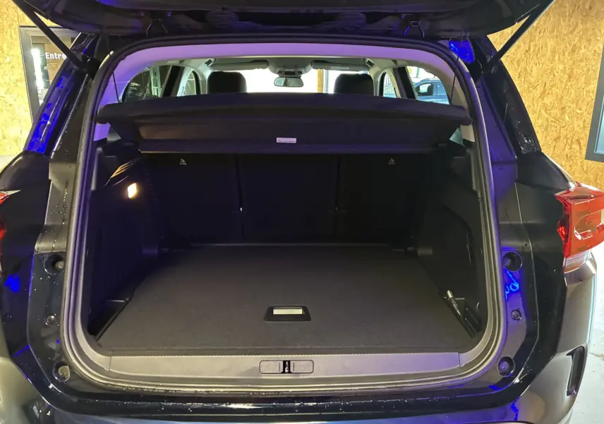 Coffre ouvert vu de l'arrière du Citroën C5 Aircross bleu Eclipse Metal, espace de chargement spacieux et bien éclairé.