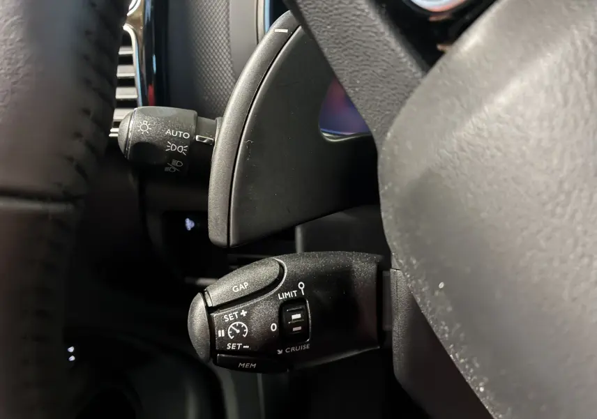 Gros plan sur la commande de régulateur de vitesse noire à gauche du volant d'un Citroën C5 Aircross 2025.