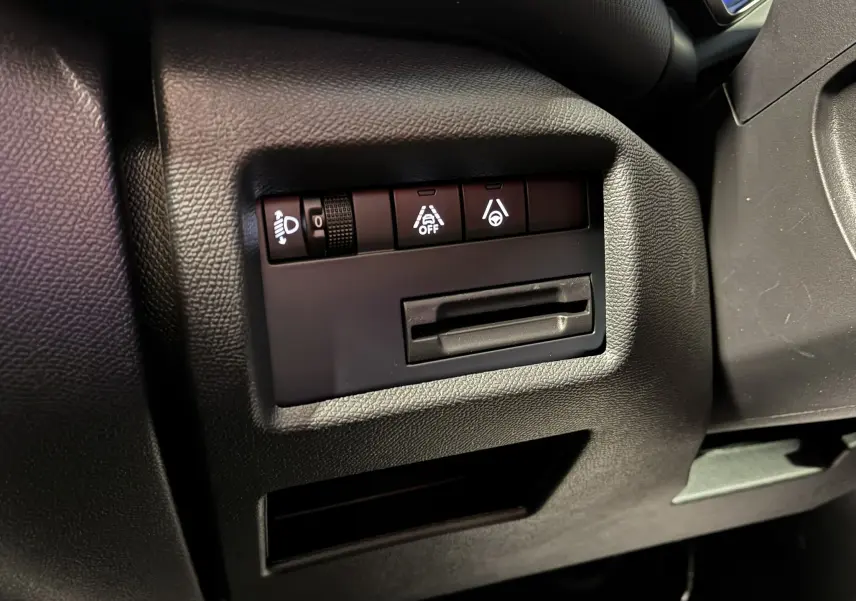 Gros plan sur les commandes de réglage des phares et aides à la conduite du tableau de bord du Citroën C5 Aircross bleu Eclipse Metal.