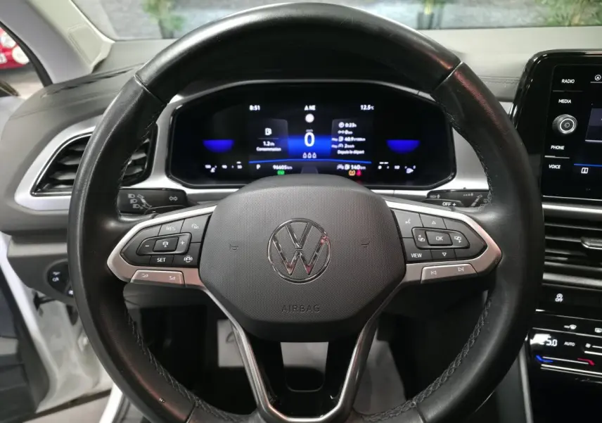 Vue rapprochée du volant cuir multifonction noir et du tableau de bord digital d'un Volkswagen T-Roc 2022.
