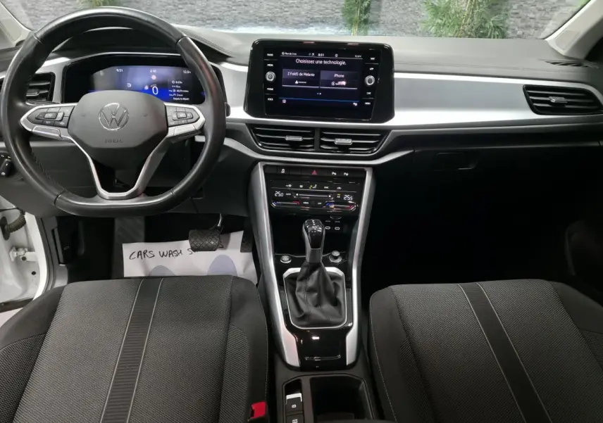 Vue intérieure avant du Volkswagen T-Roc 2022 avec tableau de bord digital, écran tactile 8 pouces et sellerie tissu noir.