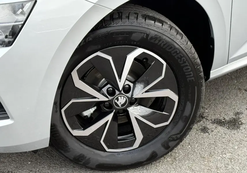 Gros plan sur la jante alliage noire et argentée du côté avant gauche d'une Skoda Kamiq gris argent 2025.