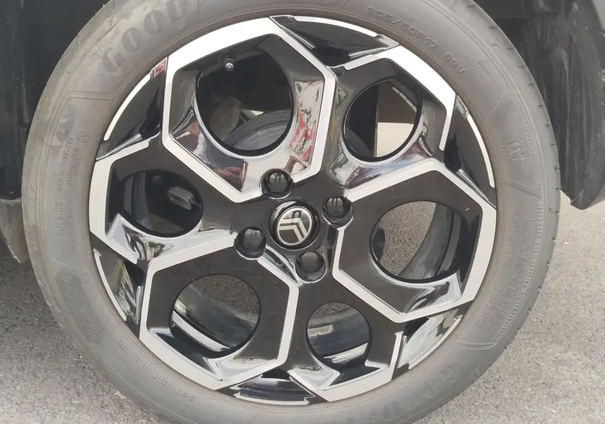 Gros plan sur la jante noire et argentée au design hexagonal d'une Citroën C3 2025 gris foncé toit noir.