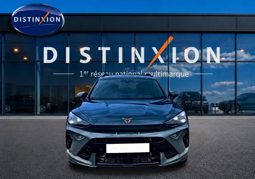 Vue frontale d'un CUPRA Formentor bleu fjord 2026 avec phares LED allumés devant une vitrine Distinxion.