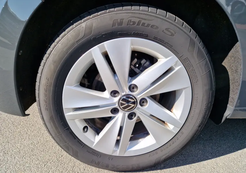 Gros plan sur la jante argentée et le pneu Nexen d'une Volkswagen Golf A8 gris Urano, détail du côté avant droit.