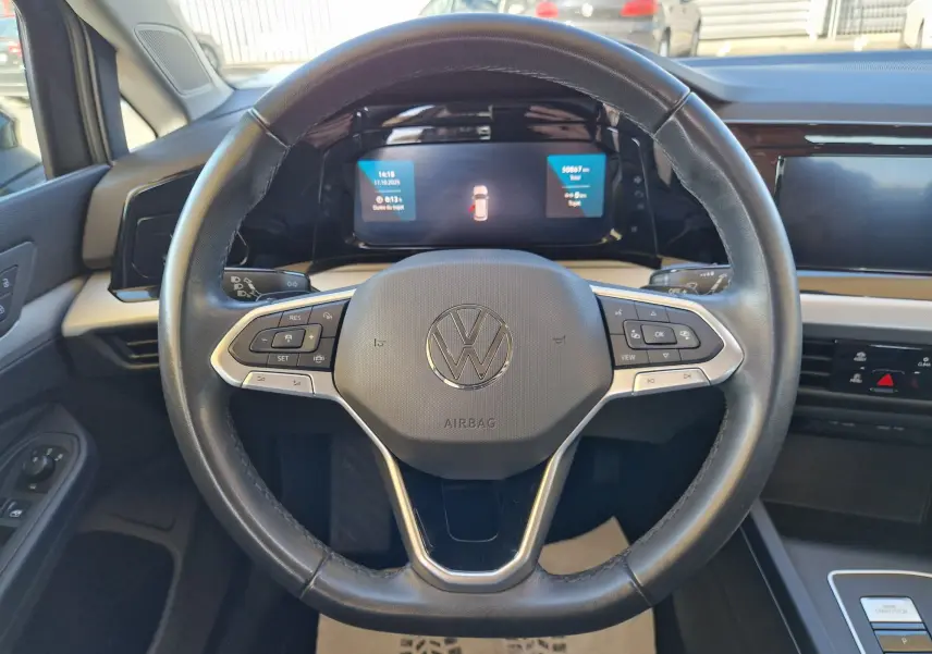 Vue rapprochée du volant noir de la Volkswagen Golf A8 2023 avec tableau de bord numérique et commandes intégrées.