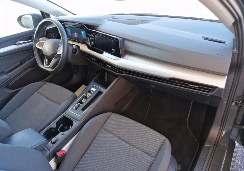 Intérieur côté conducteur de la Volkswagen Golf A8 gris Urano 2023, tableau de bord moderne avec écran tactile et volant multifonction.