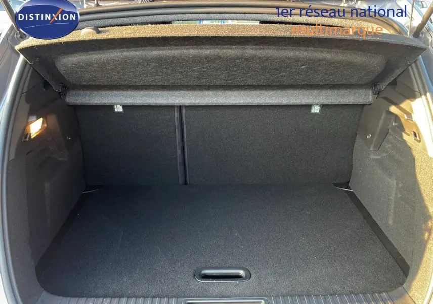 Coffre ouvert vu de l'arrière du Renault Captur E-Tech hybride gris Cassiopée, montrant un espace de chargement propre et spacieux.