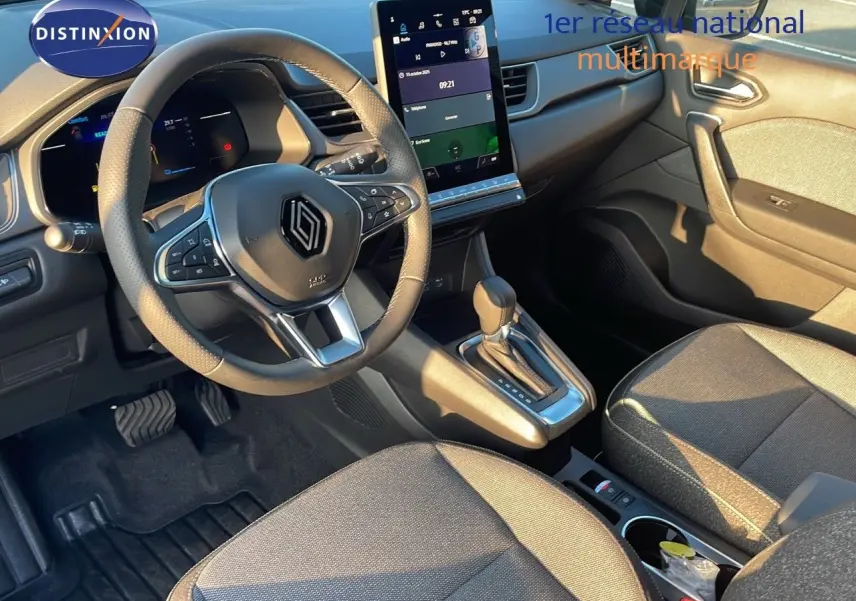 Intérieur du Renault Captur E-Tech hybride 2025, vue côté conducteur, volant multifonction et écran tactile vertical.