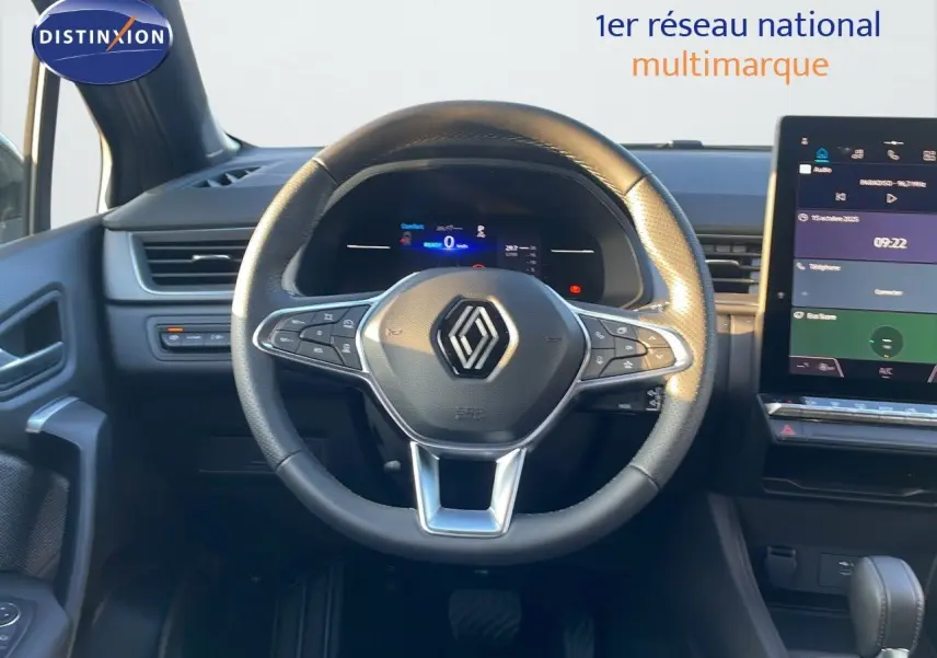 Vue centrée sur le volant du Renault Captur E-Tech hybride 2025, avec tableau de bord digital et écran tactile.