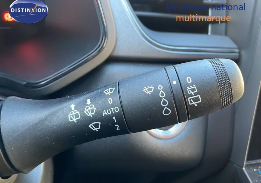 Gros plan sur la commande des essuie-glaces du tableau de bord d'un Renault Captur gris Cassiopée 2025 hybride.