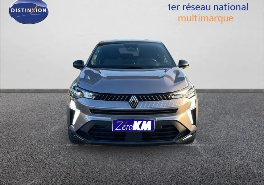 Vue frontale d'un Renault Captur E-Tech hybride gris cassiopée métal avec calandre moderne et feux LED allumés.