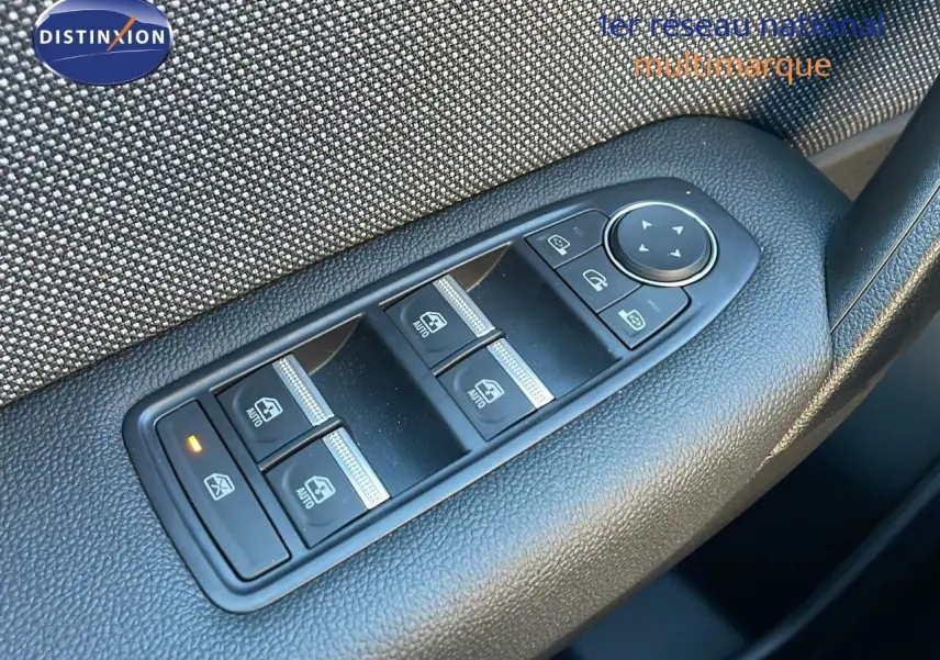 Gros plan sur les commandes des vitres électriques et rétroviseurs sur la portière côté gauche du Renault Captur gris cassiopée 2025.