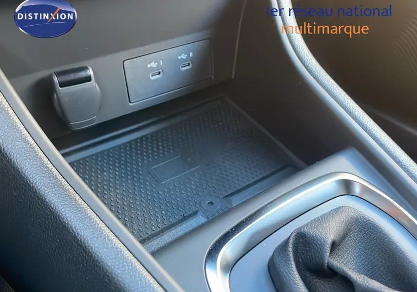 Gros plan sur la console centrale du Renault Captur gris cassiopée, montrant les ports USB et le rangement antidérapant.