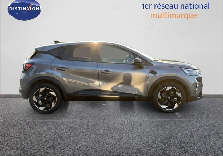Profil droit du Renault Captur E-Tech hybride gris cassiopée métal avec jantes noires et toit noir contrasté.