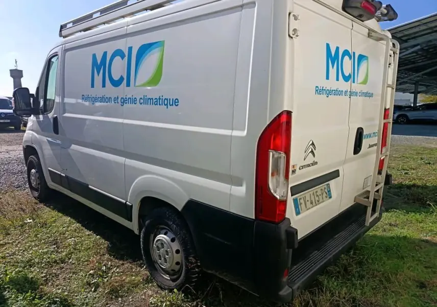 Vue 3/4 arrière droite d'un utilitaire blanc Citroën Jumper L1H1 avec logo MCI et galerie sur le toit.