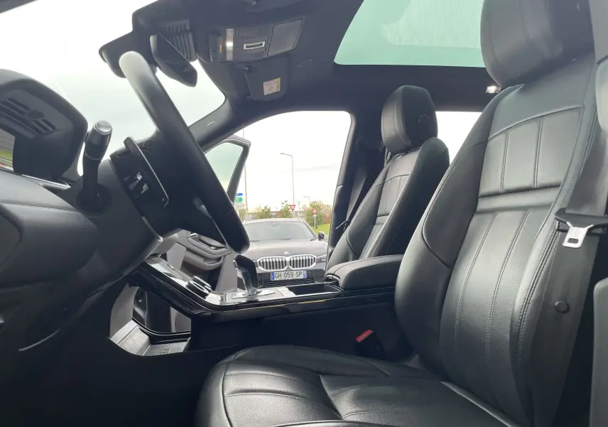 Vue intérieure côté conducteur du Range Rover Evoque 200D SE R-Dynamic 2021 avec sièges cuir noir et toit panoramique.
