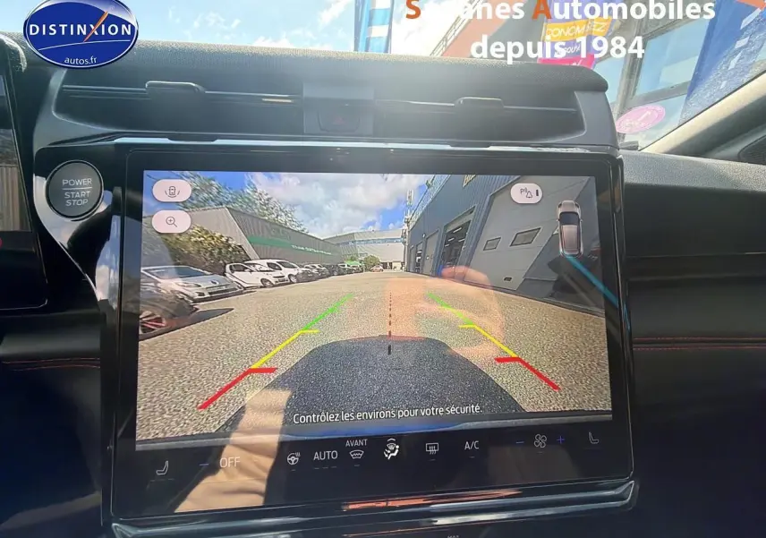 Vue intérieure sur l'écran de caméra de recul du Ford Puma bleu, avec commandes et tableau de bord visibles.