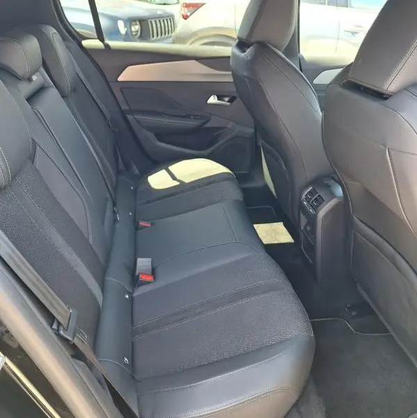Vue intérieure côté droit des sièges arrière noirs en tissu et cuir du Peugeot 308 Hybrid 145 e-DCS6 GT 2025.