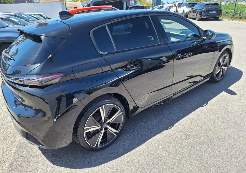 Peugeot 308 Hybrid 145 GT noir vue 3/4 arrière droit, jantes alliage 18 pouces et vitres teintées.