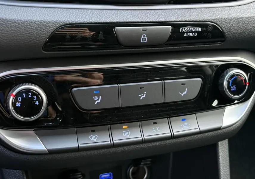 Gros plan sur la console centrale de la Hyundai i30 SW T-GDI 120 Modern 2025, boutons de climatisation et verrouillage.