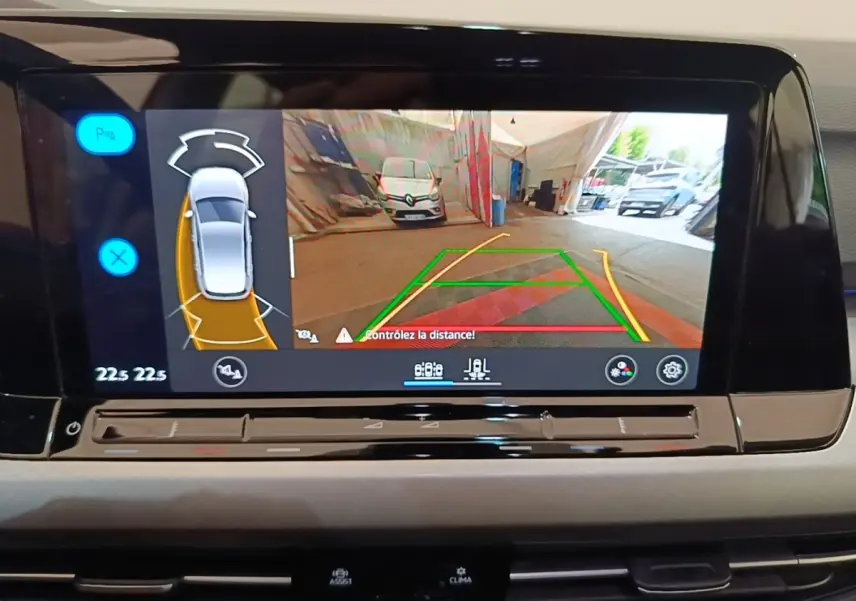 Écran tactile central affichant la caméra de recul et l’aide au stationnement de la Volkswagen Golf noire 2023.