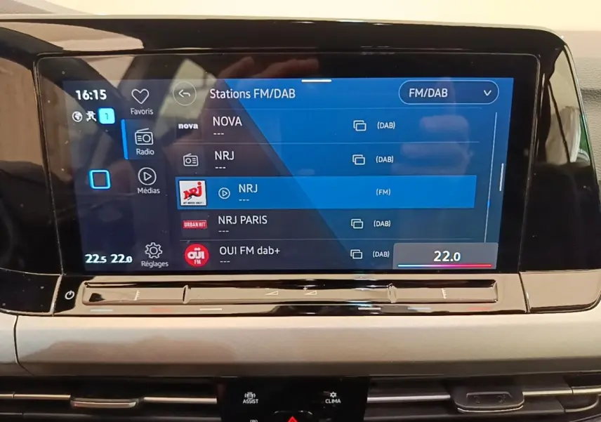 Écran tactile central affichant les stations radio FM/DAB dans l’habitacle d’une Volkswagen Golf noire 2023.