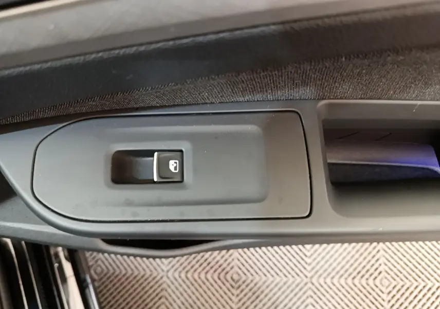 Gros plan sur le bouton de verrouillage centralisé dans la portière côté conducteur d'une Volkswagen Golf noire 2023.