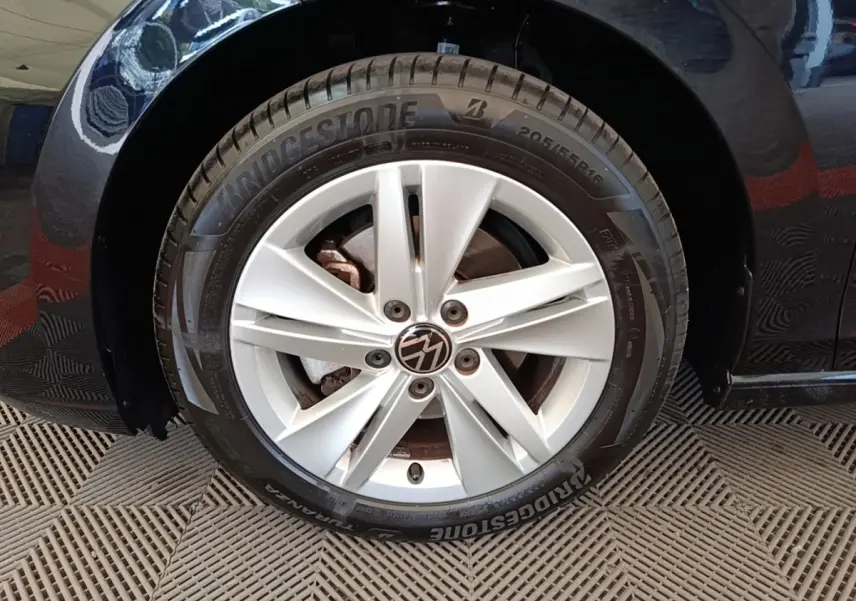 Gros plan sur la roue avant gauche argentée d'une Volkswagen Golf noire 2023 avec pneu Bridgestone.