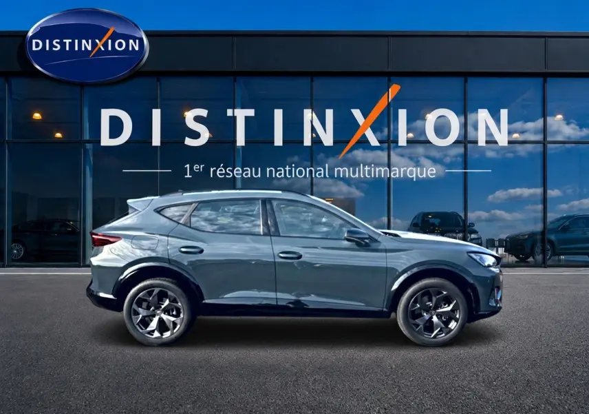 Vue latérale droite d'un CUPRA Formentor bleu fjord 2026 avec jantes 18 pouces devant une vitrine Distinxion.