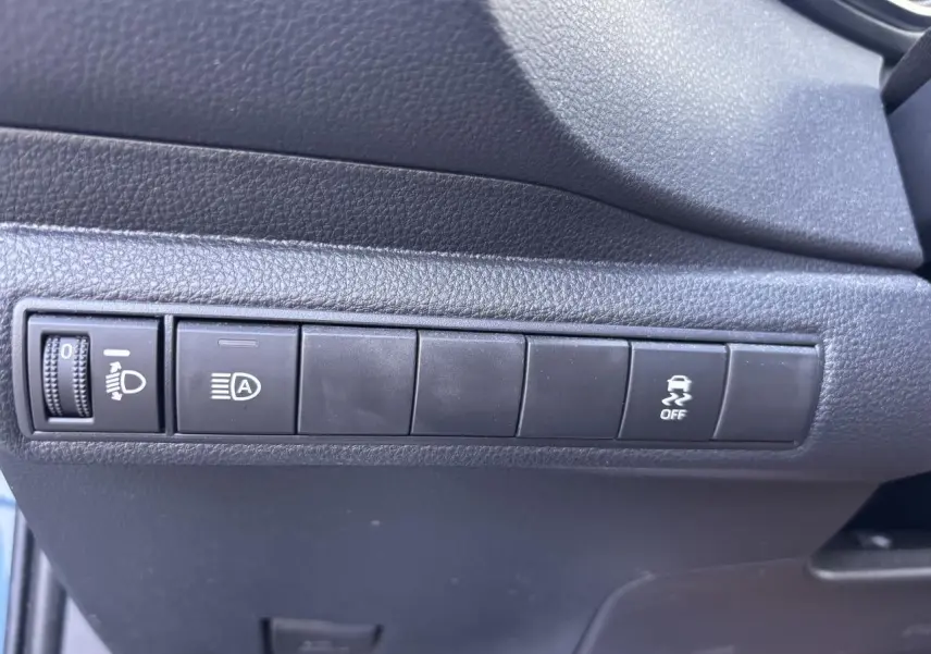 Gros plan sur les commandes noires du tableau de bord côté gauche de la Toyota Corolla hybride bleu clair 2020.